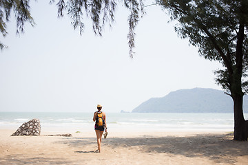 Image showing Young brunette walking along beach