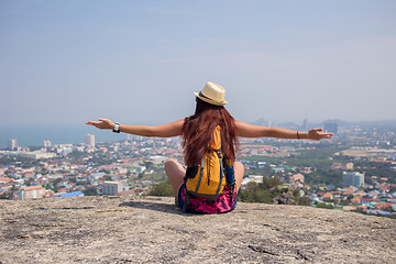 Image showing Girl sits back on hill