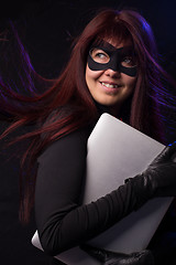 Image showing Thief in mask holds laptop