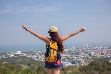 Image showing Brunette stands with arms raised