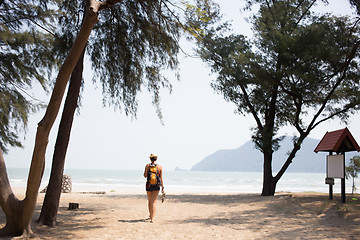 Image showing Young woman walks along beach