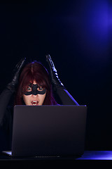 Image showing Young brunette hacker with laptop