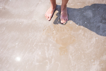 Image showing Girl\'s legs on sea shore