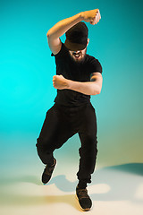 Image showing The silhouette of one hip hop male break dancer dancing on colorful background