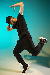 Image showing The silhouette of one hip hop male break dancer dancing on colorful background