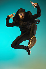 Image showing The silhouette of one hip hop male break dancer dancing on colorful background