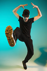 Image showing The silhouette of one hip hop male break dancer dancing on colorful background