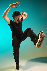 Image showing The silhouette of one hip hop male break dancer dancing on colorful background