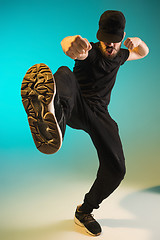 Image showing The silhouette of one hip hop male break dancer dancing on colorful background