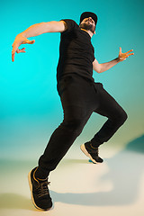 Image showing The silhouette of one hip hop male break dancer dancing on colorful background