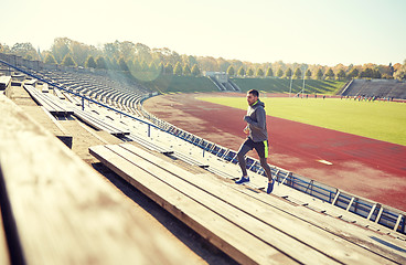 Image showing happy young man running upstairs on stadium