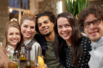 Image showing happy friends with drinks at bar or cafe