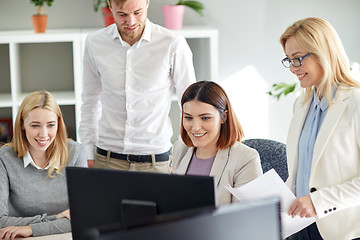 Image showing happy business team with computer in office