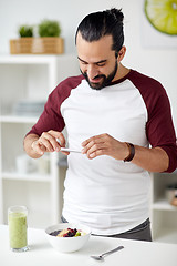 Image showing man photographing breakfast by smartphone at home