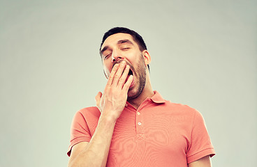 Image showing yawning man over gray background