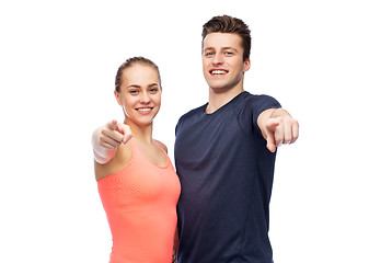 Image showing happy sportive man and woman pointing finger