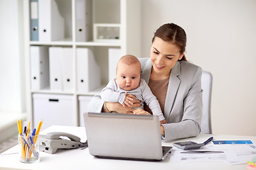 Image showing happy businesswoman with baby and laptop at office