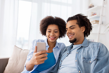 Image showing happy couple with smartphones at home