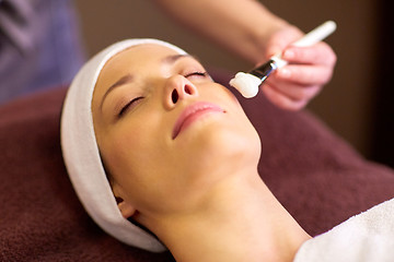 Image showing beautician applying facial mask to woman at spa