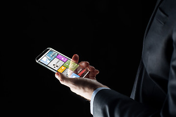 Image showing close up of businessman with apps on smartphone