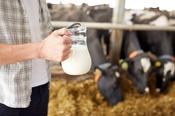 Image showing close up of man or farmer with milk on dairy farm