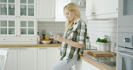 Image showing Young woman using phone at home