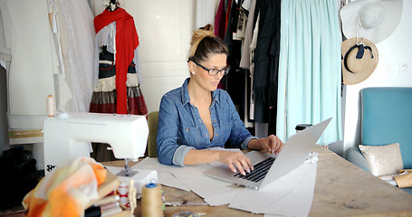 Image showing Tailor using laptop in parlour