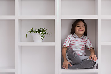 Image showing young boy posing on a shelf