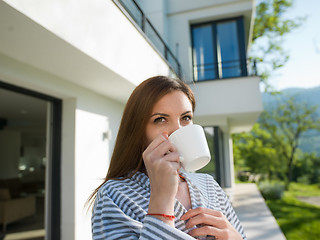 Image showing woman in a bathrobe enjoying morning coffee