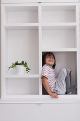 Image showing young boy posing on a shelf