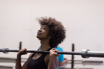 Image showing black woman lifting empty bar