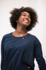 Image showing African American woman blowing confetti in the air