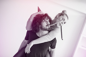 Image showing couple in party hats blowing in whistle