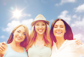 Image showing group of happy smiling women or friends over sky