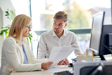 Image showing business team discussing papers at office table