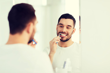 Image showing man with toothbrush cleaning teeth at bathroom