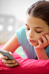 Image showing close up of bored girl with smartphone at home