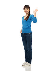 Image showing happy smiling young woman waving hand over white