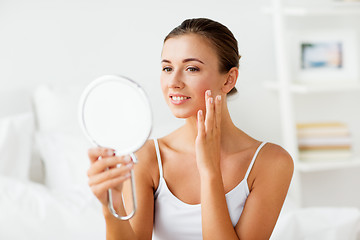 Image showing beautiful woman with mirror touching her face skin