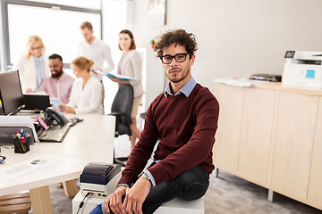 Image showing happy young man over creative team in office