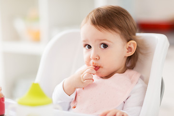 Image showing happy baby girl sitting in highchair at home