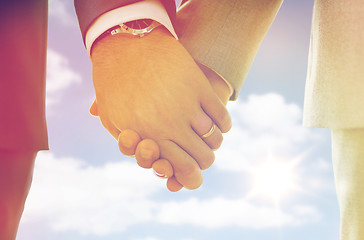 Image showing close up of male gay hands with wedding rings on