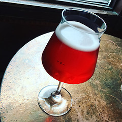 Image showing Glass of seasonal cherry beer on a bar table