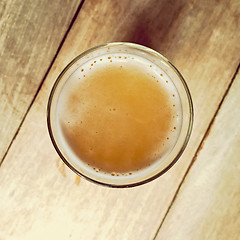 Image showing Glass of beer on a wooden bar table