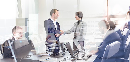 Image showing Business people shaking hands in moder corporate office.