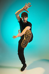 Image showing The silhouette of one hip hop male break dancer dancing on colorful background