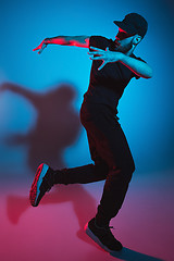 Image showing The silhouette of one hip hop male break dancer dancing on colorful background