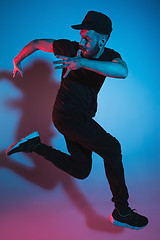 Image showing The silhouette of one hip hop male break dancer dancing on colorful background