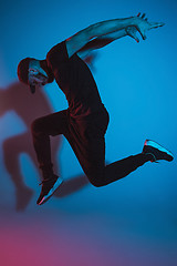 Image showing The silhouette of one hip hop male break dancer dancing on colorful background