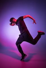 Image showing The silhouette of one hip hop male break dancer dancing on colorful background